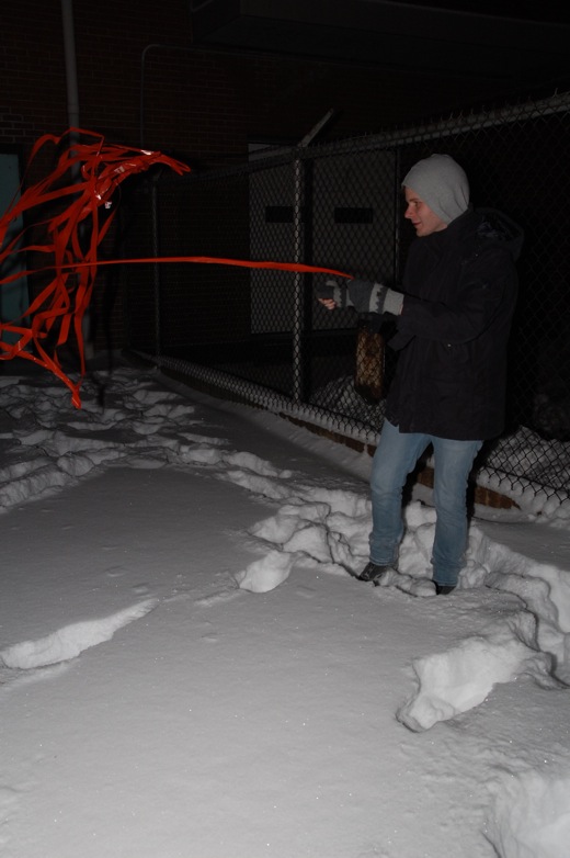 Steven struggling against the wind with the flagging tape