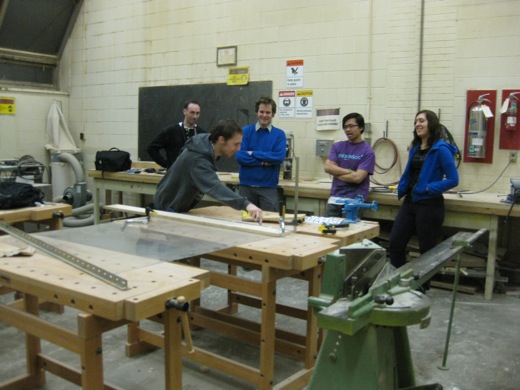 Everyone supervises Josh score the plexiglass