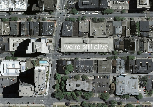 we're still alive: a message to the world, annotating Windsor on the rooftops of parking garages, by Broken City Lab