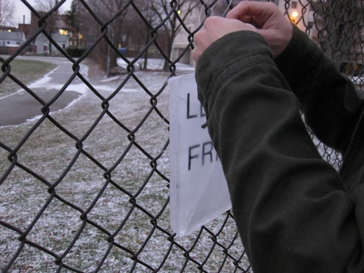 installing Let's Be Friends in Windsor, Ontario on a chain link fence